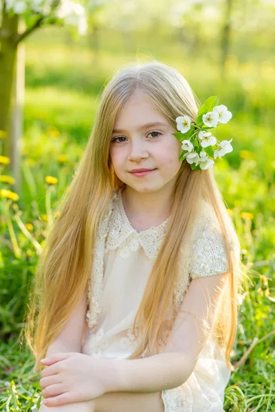 一个美丽的小女孩穿过 s 开花花园 — 图库照片