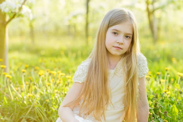 Egy gyönyörű kislány végigfut egy virágzó kert a s — Stock Fotó