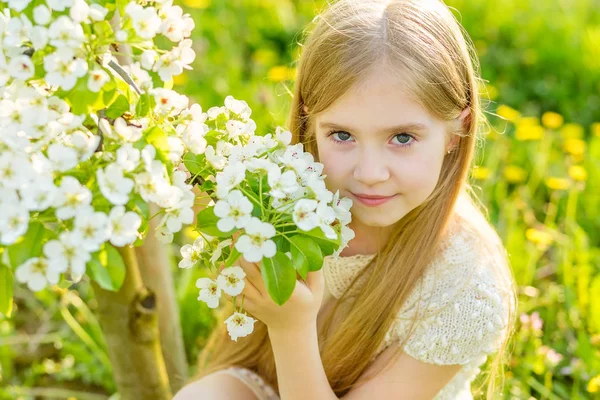 Uma menina bonita corre através de um jardim florido no s — Fotografia de Stock