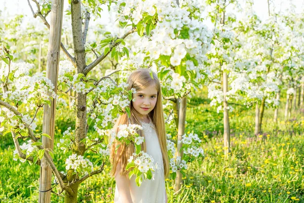 Une belle petite fille court à travers un jardin fleuri dans le s — Photo