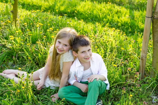 Ένα αγόρι και ένα κορίτσι αναπαύονται σε έναν ανθισμένο κήπο την άνοιξη — Φωτογραφία Αρχείου