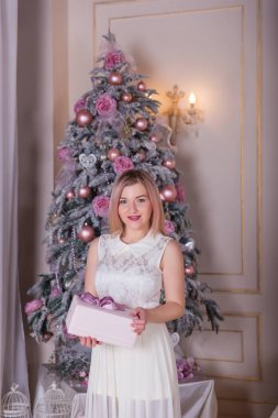 Güzel sarışın Noel süslemeleri beyaz bir elbise içinde