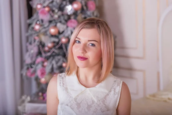 Όμορφη ξανθιά σε ένα λευκό φόρεμα σε χριστουγεννιάτικα διακοσμητικά παιχνίδια — Φωτογραφία Αρχείου