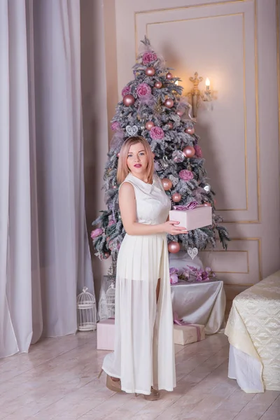 Bella bionda in un abito bianco in decorazioni natalizie — Foto Stock
