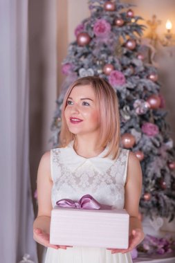 Güzel sarışın Noel süslemeleri beyaz bir elbise içinde