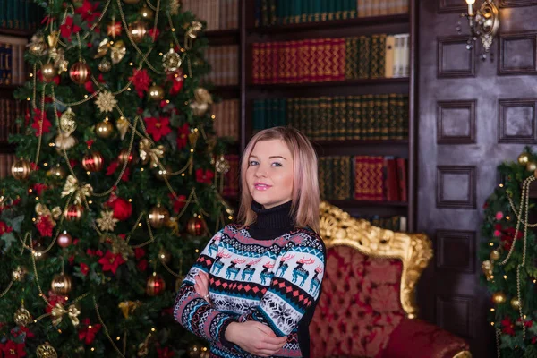 Belle fille aux cheveux blonds dans un pull près du t de Noël — Photo