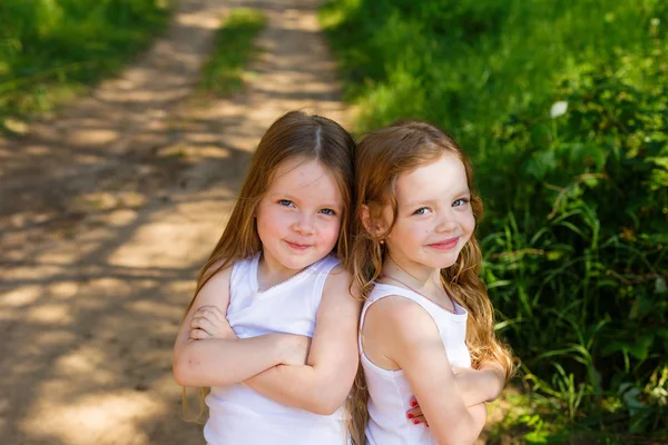 Két kis lány lány baráti öleléssel az erdő — Stock Fotó
