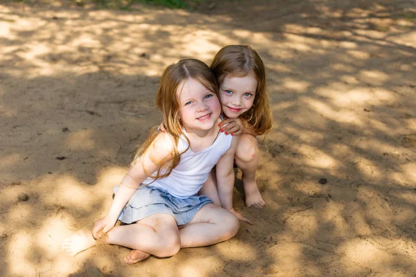 Two little girl girl friends hugging in the forest — Stock Photo, Image