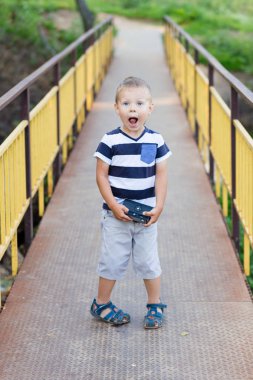 Küçük bir çocuk onun elinde eski bir kamera ile bir o duruyor