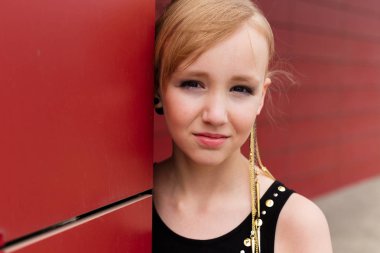 Kırmızı bir duvara poz siyah elbiseli güzel sarışın kız 