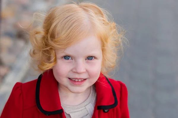 Πορτρέτο του ένα όμορφο μικρό κορίτσι με τα κόκκινα μαλλιά σε ένα κόκκινο παλτό — Φωτογραφία Αρχείου