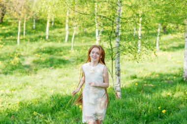 Karahindiba ile bir parkta uzun saçlı güzel kızıl saçlı kız