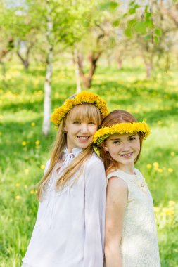 Kız onların hea dandelions çelenk ile ayakta
