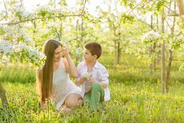 Anne yavaşça oğlu batan güneşin ışınları hugs.