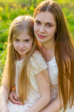 Güzel anne ve kızı ilkbaharda çiçek açan bir bahçede