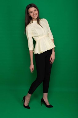 Sarı bir bluz ve siyah pantolon bir yeşil güzel esmer