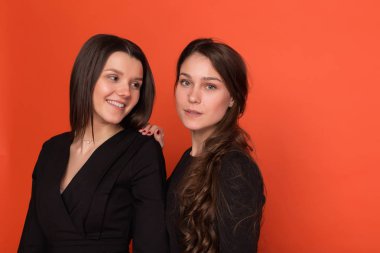 İki güzel genç kadınlar iş kırmızı bir arka plan üzerinde uygun 