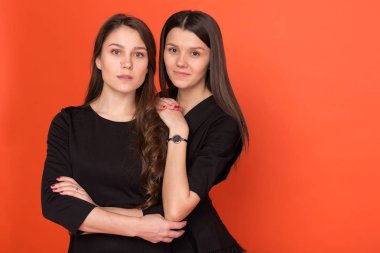 İki güzel genç kadınlar iş kırmızı bir arka plan üzerinde uygun 