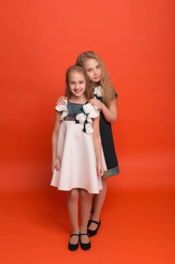 Güzel stilize elbiseler kırmızı bir arka plan üzerinde iki kız kardeş