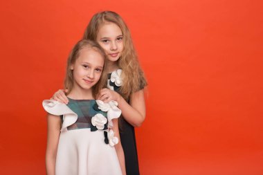 Güzel stilize elbiseler kırmızı bir arka plan üzerinde iki kız kardeş