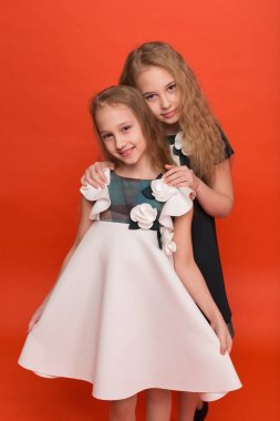 Güzel stilize elbiseler kırmızı bir arka plan üzerinde iki kız kardeş