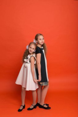 Güzel stilize elbiseler kırmızı bir arka plan üzerinde iki kız kardeş