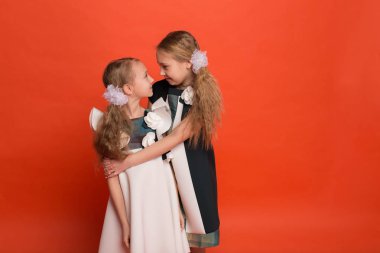 Güzel stilize elbiseler kırmızı bir arka plan üzerinde iki kız kardeş