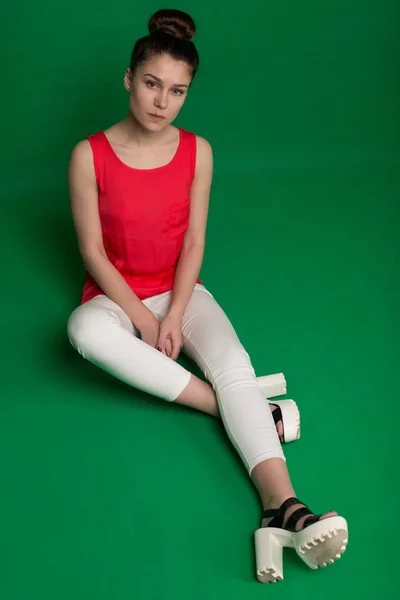 Hermosa joven en una blusa roja y pantalones blancos en un género — Foto de Stock