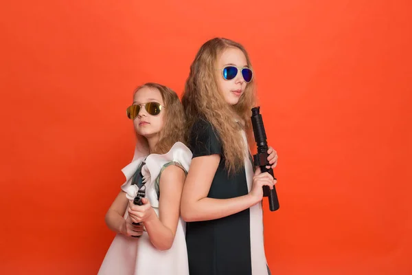 Two girls in military dresses with arms in hand and sunglasses o — Stock Photo, Image