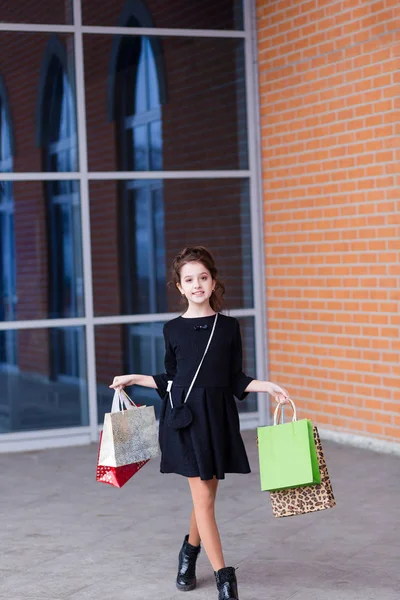 Menina bonita com um monte de pacotes na saída do — Fotografia de Stock