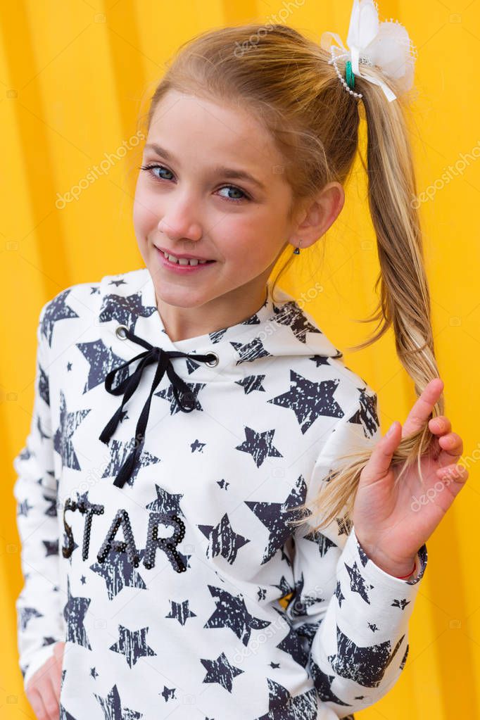 Portrait of a beautiful blonde girl on a yellow background 