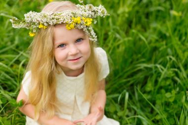 Güzel küçük bir kız ile bir çelenk içinde flo oynarken başında