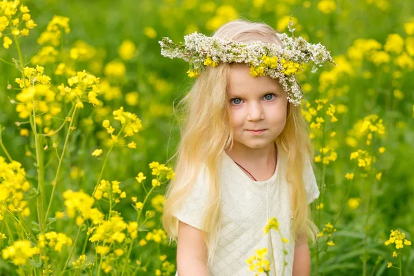 Güzel küçük bir kız ile bir çelenk içinde flo oynarken başında