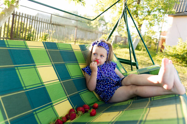 Portrait of a little girl eating a strawberry