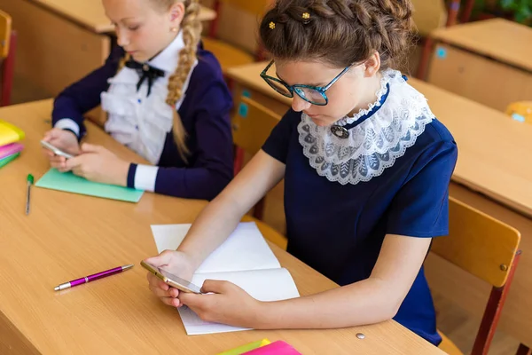 Die Kinder sitzen im Unterricht in den Telefonen — Stockfoto