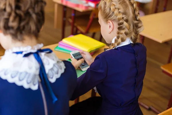 De kinderen zitten in de telefoons bij de lessen — Stockfoto