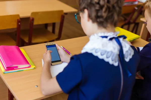 De kinderen zitten in de telefoons bij de lessen — Stockfoto