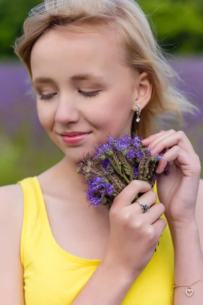 Retrato de cerca de una niña en flores púrpura al aire libre en verano —  Fotos de Stock