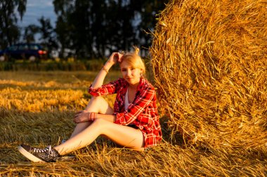 Bir alandaki saman sheaves genç kız