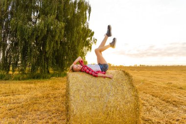 Bir alandaki saman sheaves genç kız