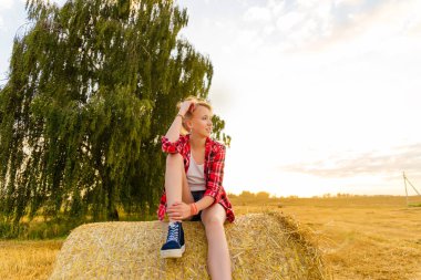Bir alandaki saman sheaves genç kız