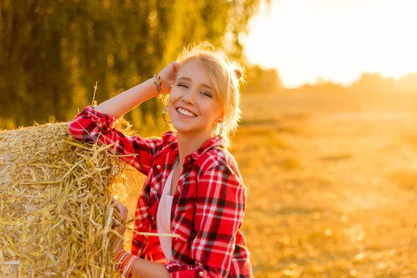 Bir alandaki saman sheaves genç kız