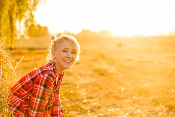 Bir alandaki saman sheaves genç kız