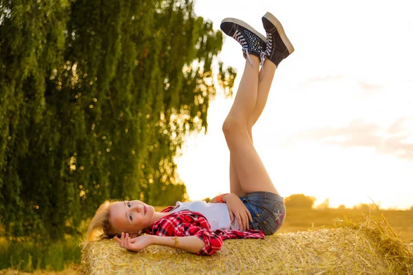 Bir alandaki saman sheaves genç kız