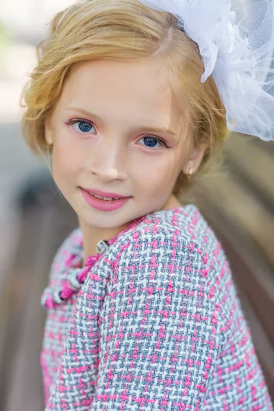 Retrato de una rubia vestida de rosa en un parque al aire libre . — Foto de Stock