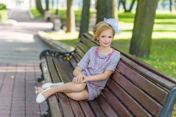 Retrato de uma loira de traje rosa em um parque ao ar livre . — Fotografia de Stock