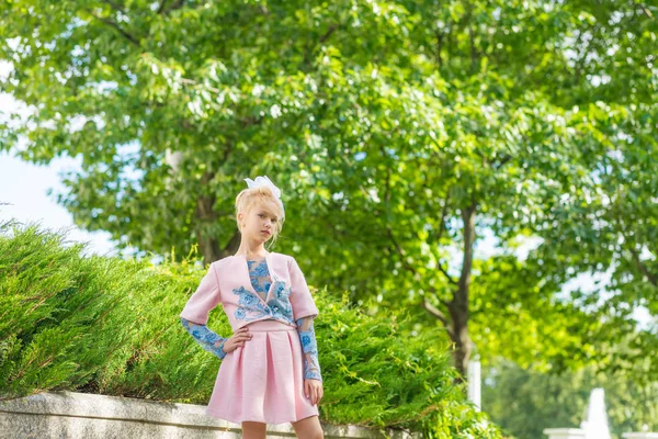 Portrét blondýnu v růžové oblečení v parku venku. — Stock fotografie
