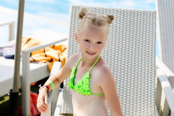 Menina em um maiô em uma prateleira à beira da piscina — Fotografia de Stock