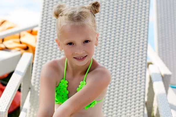 Junges Mädchen im Badeanzug auf einem Regal am Pool — Stockfoto