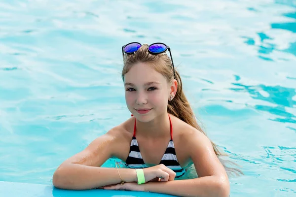 Schönes Mädchen im Badeanzug schwimmt im Pool — Stockfoto
